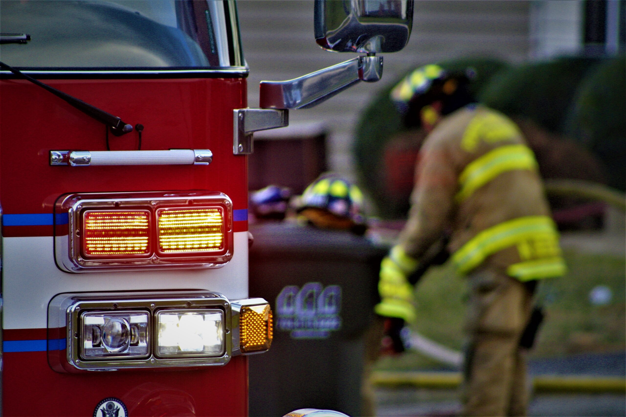 Firefighters standing next to red fire truck